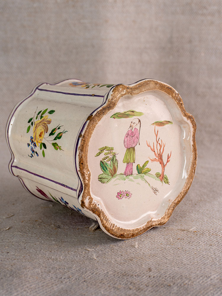 Antique French faience cache pot, 18th century, hand-painted chinoiserie and floral motifs, shown on textured fabric.