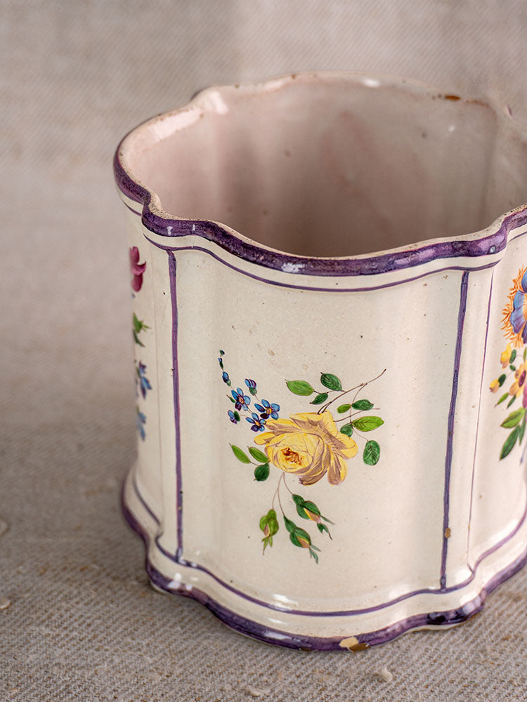 Antique French faience cache pot with scalloped rim, hand-painted yellow roses, blue flowers, and purple border on beige surface.