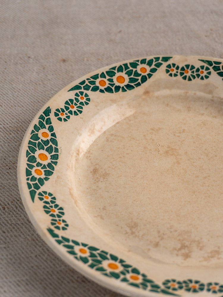 Antique French Faience plate, HBCM Creil Montereau Trebeurden, green-yellow floral rim, vintage patina, on light textured fabric.
