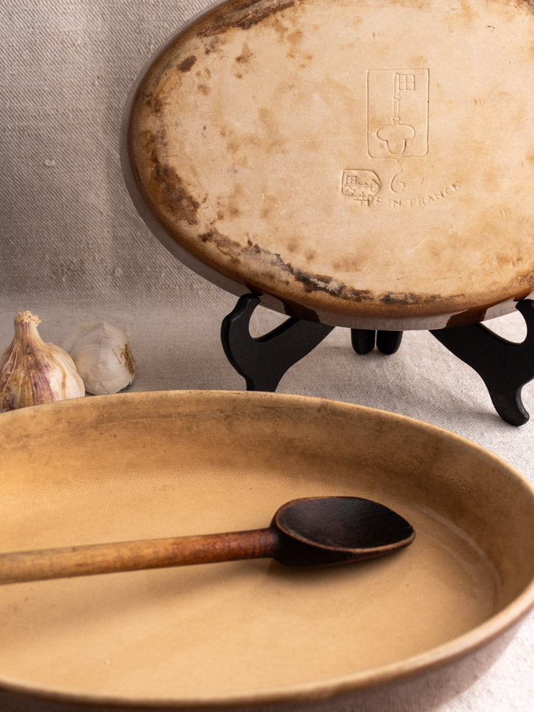 Pair of vintage French La Bourguignonne stoneware gratin dishes with “Made in France” mark, garlic, and wood spoon.