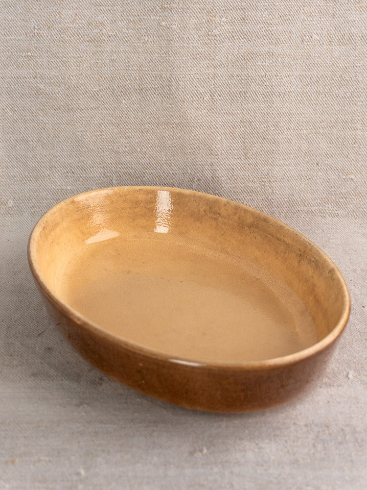 Pair of vintage French La Bourguignonne brown stoneware gratin dishes on textured fabric background.