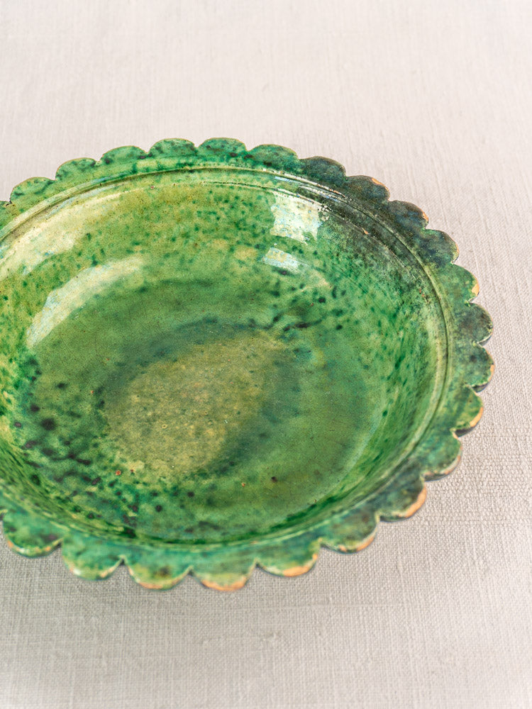 Antique French earthenware bowl with Provençal green glaze, scalloped edges, and speckled finish.
