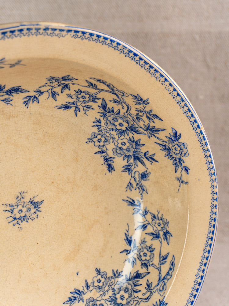 Antique French Grigny Terre de Fer saladier with blue floral transferware on beige ceramic, aged patina.