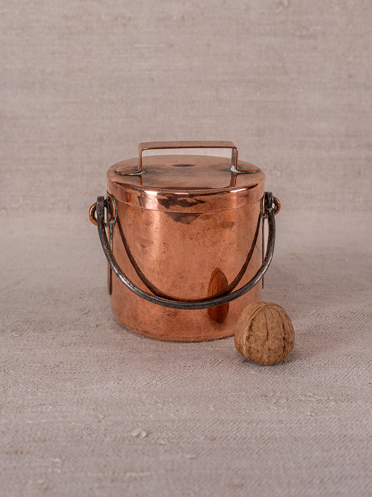 19th-century French copper apprentice set with daubiere, saucepans, lid, black handle on light fabric, walnut nearby.