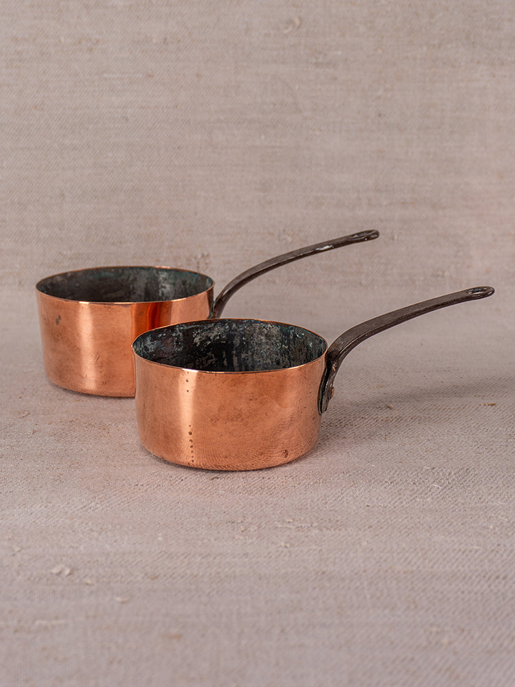 Antique French copper daubiere set with two small saucepans, patina, and darkened interiors for collectors or chefs.