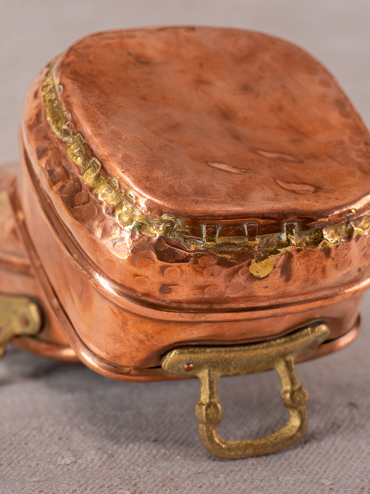 Pair of antique French hammered copper pots with brass handles, late 19th–early 20th century, on light fabric.