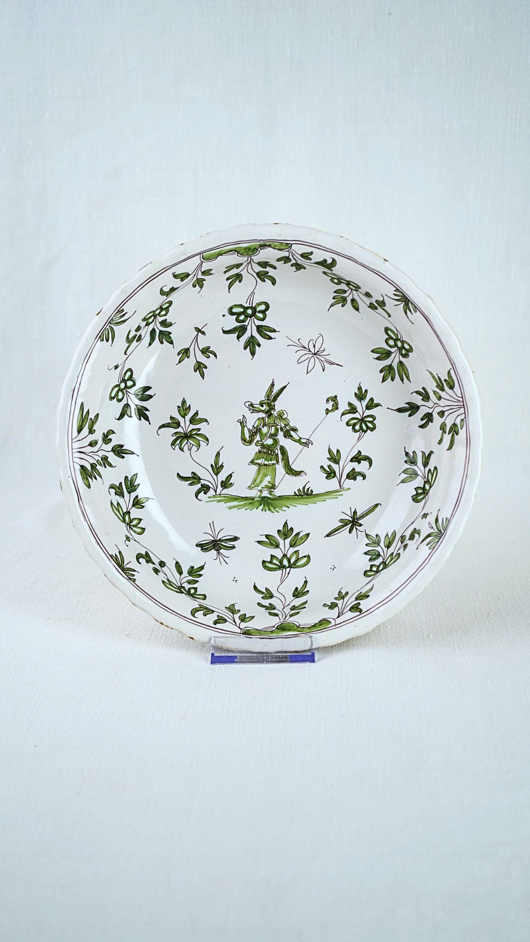 18th-century French faïence bowl from Bordeaux featuring green Chinoiserie figures and leaf motifs.