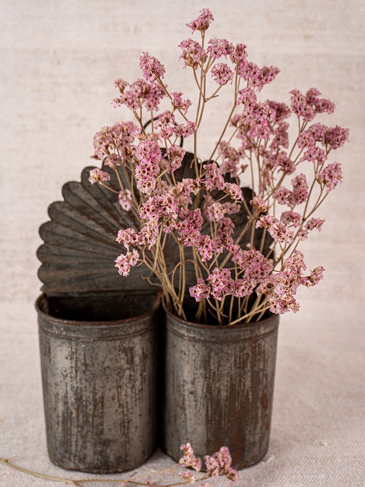 Provençal wall mounted utensil holder in aged steel with pink dried flowers and fan-shaped metal accent.