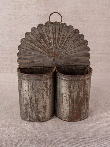Provençal wall-mounted utensil holder in aged steel with dual compartments, vintage patina, on neutral fabric background.