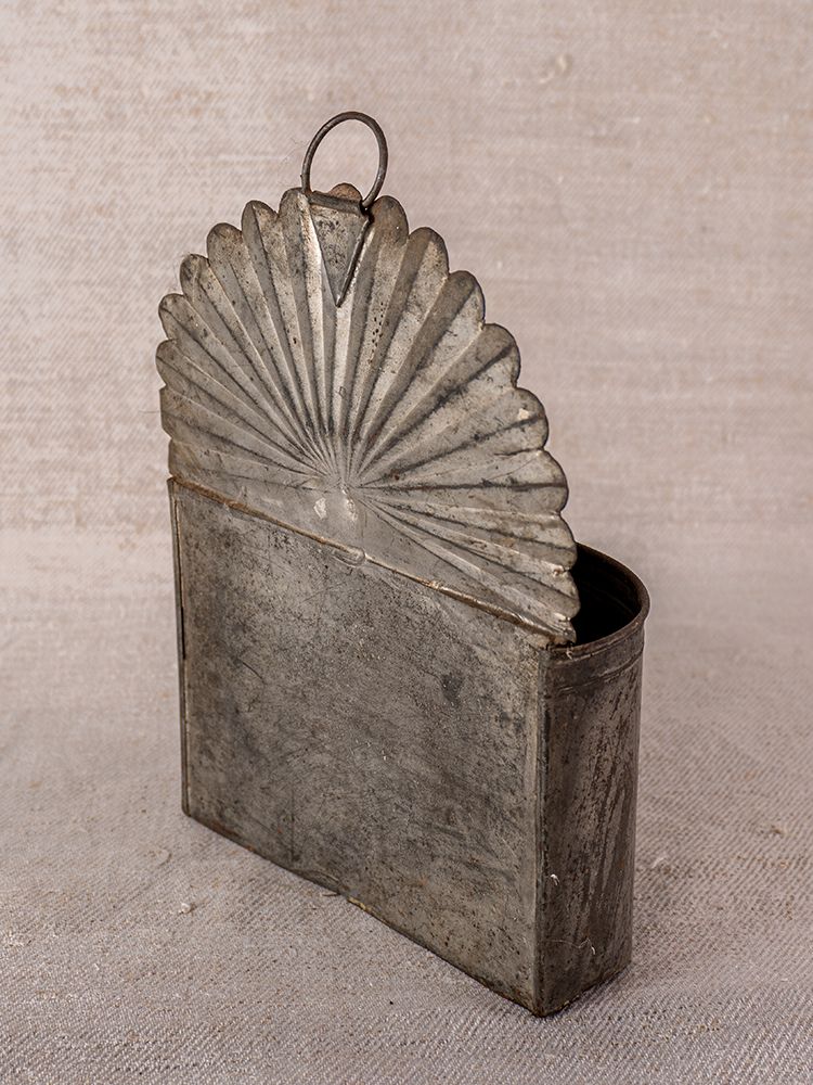 Provençal wall-mounted utensil holder in aged steel with vintage detailing against a neutral textured background.