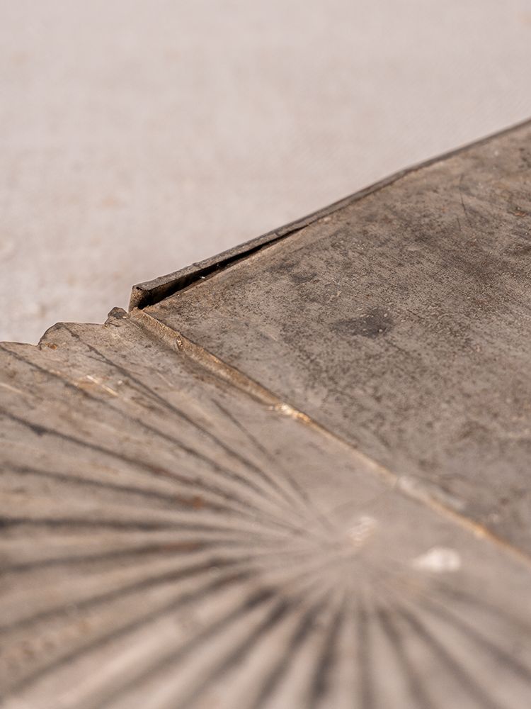 Provençal wall-mounted utensil holder in aged steel with sunburst pattern, textured, scratched, and weathered surface.