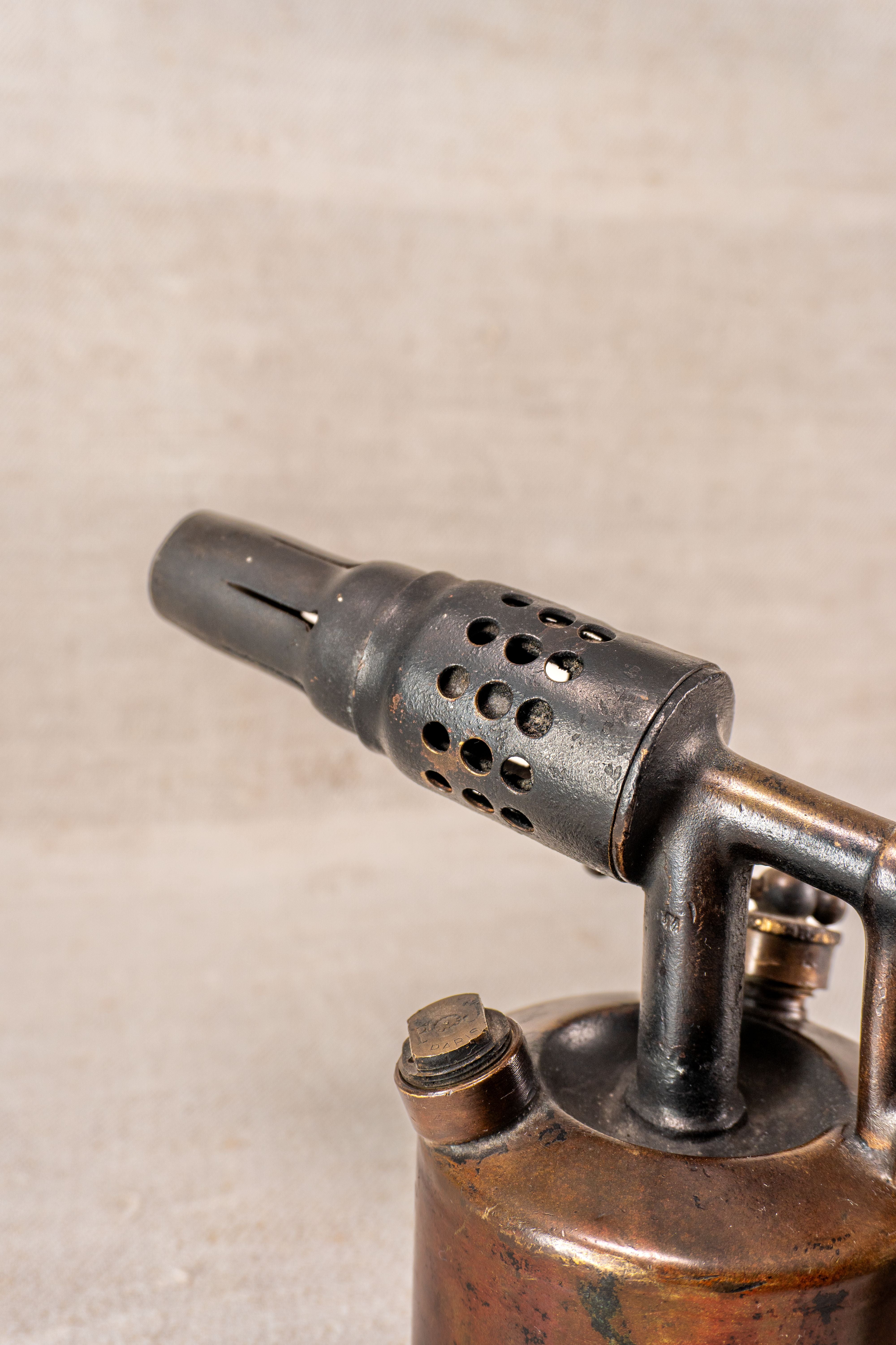 Vintage French blowtorch by Vesta F.J. Paris, circa 1920, with weathered body and perforated metal nozzle.