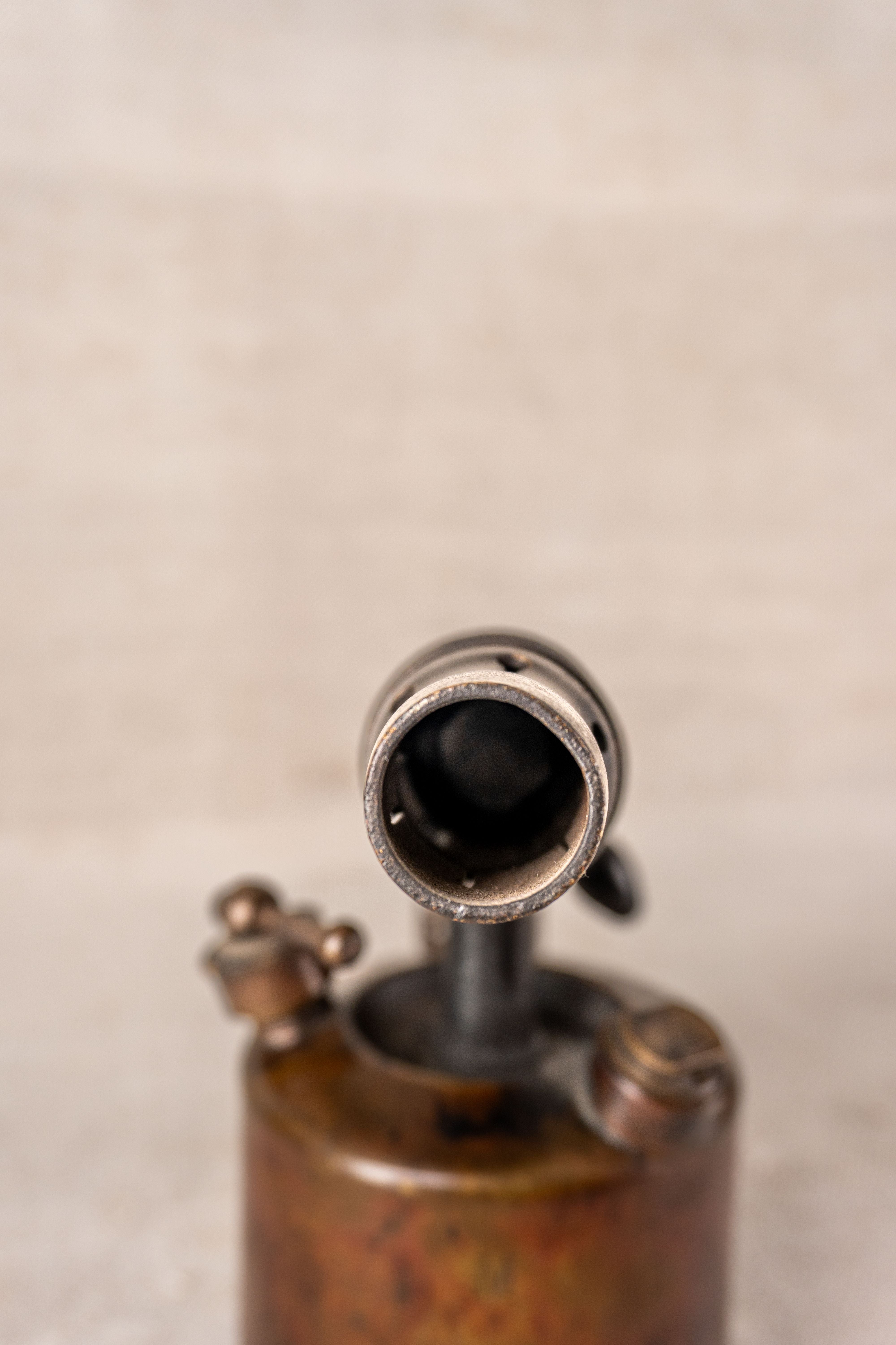 Vintage French blowtorch nozzle by Vesta F.J. Paris, c.1920, with aged metal patina and blurred neutral backdrop.