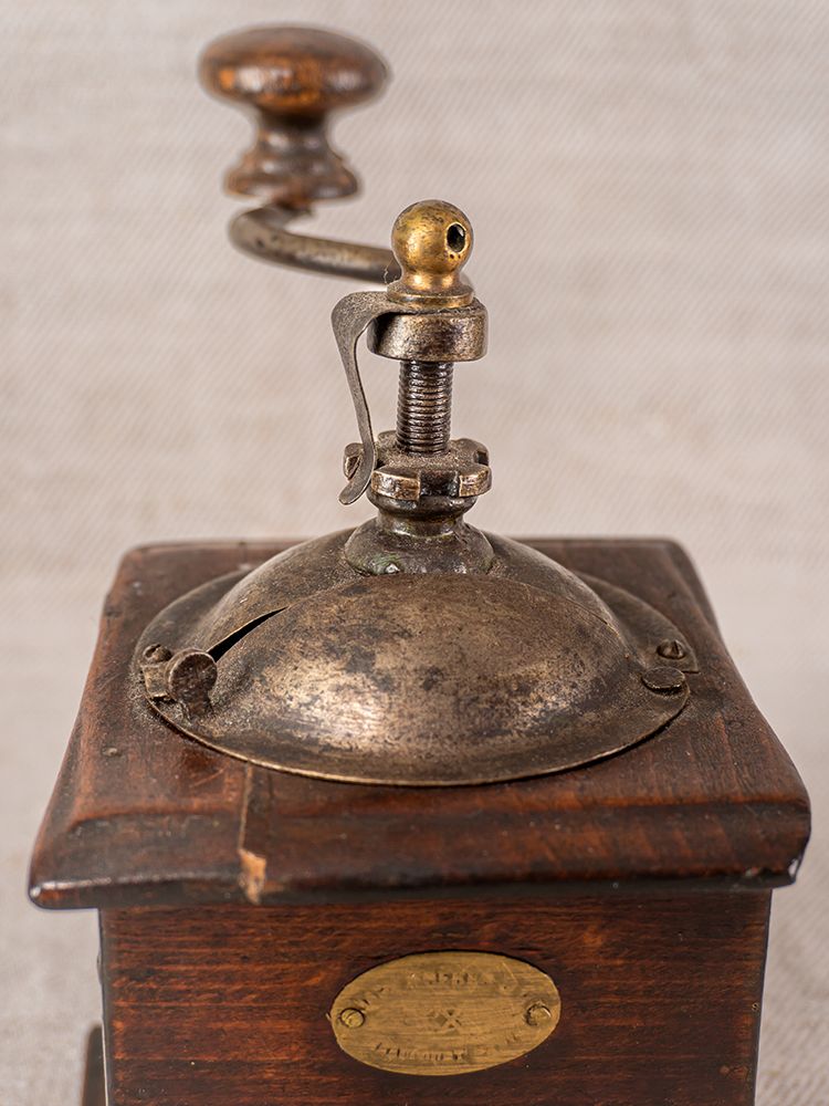 Antique French Peugeot Frères coffee grinder, late 19th century, with metal top, wooden base, crank handle, and brass nameplate.