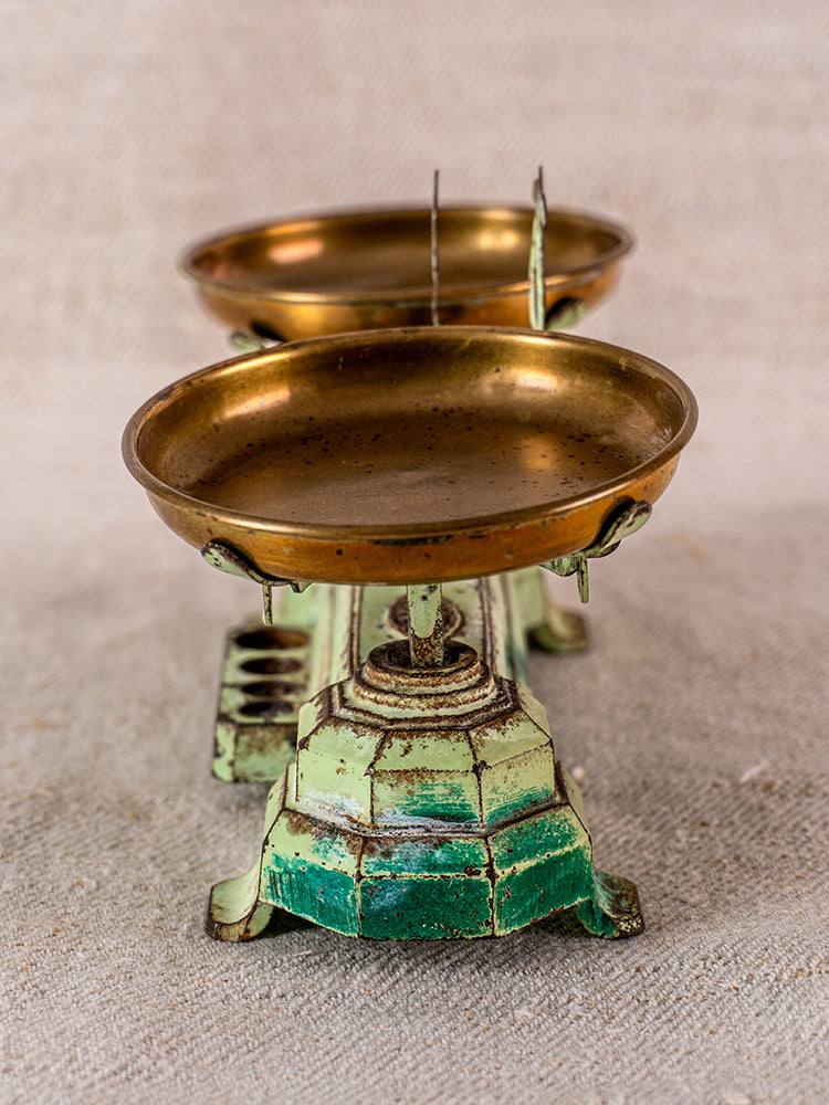 Vintage French JEP toy balance scale in green cast iron and brass with dual trays on neutral background.