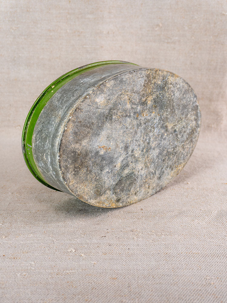 Vintage Swiss brass jardinière featuring embossed fruit motif, displayed on textured beige fabric background.