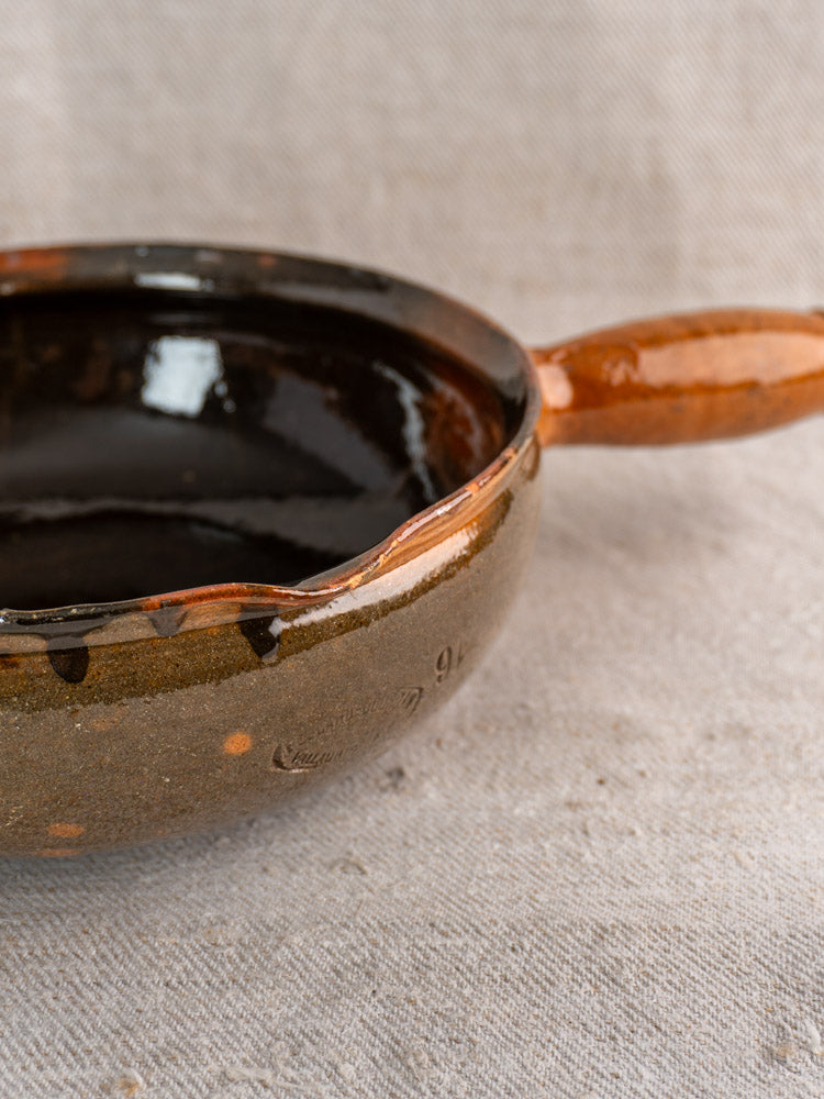 Antique French Vallauris poêlon by Grandjean Jourdan, brown ceramic with glossy black interior and single handle.