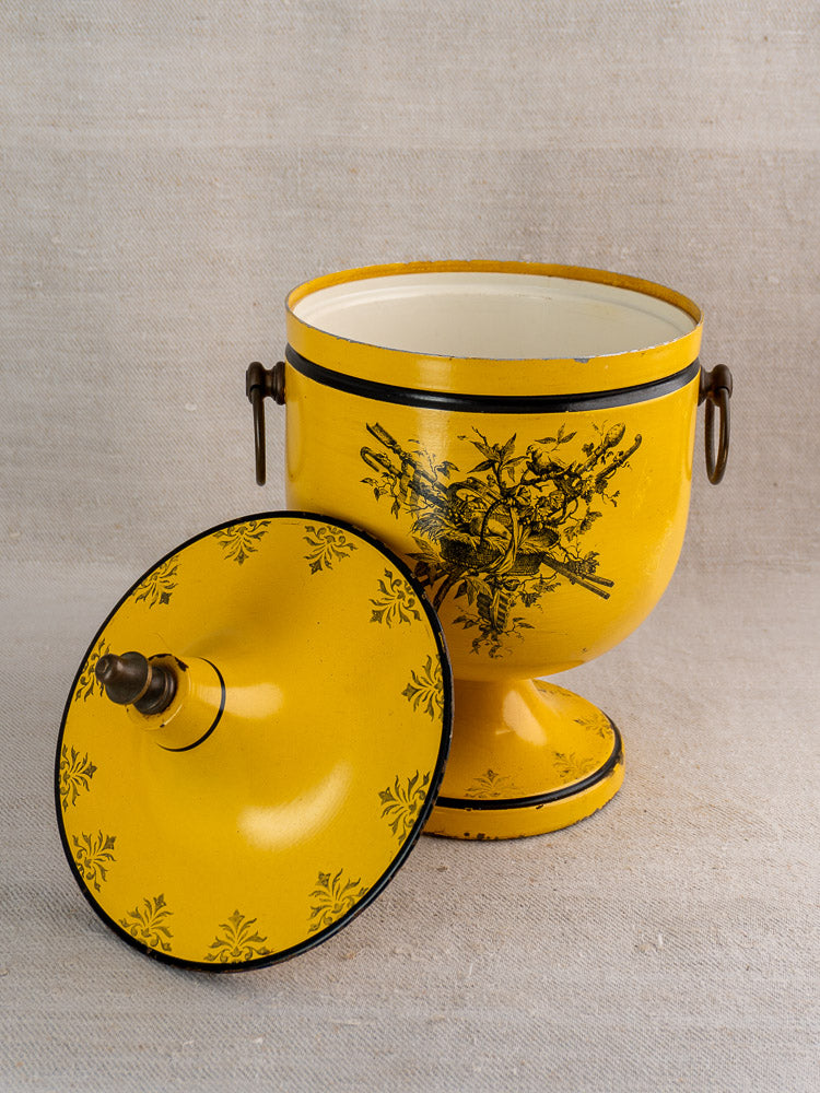 Vintage French yellow Tôle Peinte champagne cooler in Directoire style with black floral motifs, lid aside.