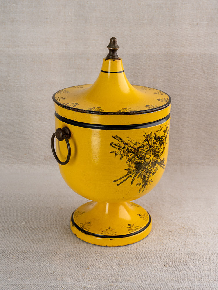 Vintage French yellow Directoire tôle peinte champagne cooler with black floral designs, metal handle, pointed finial.