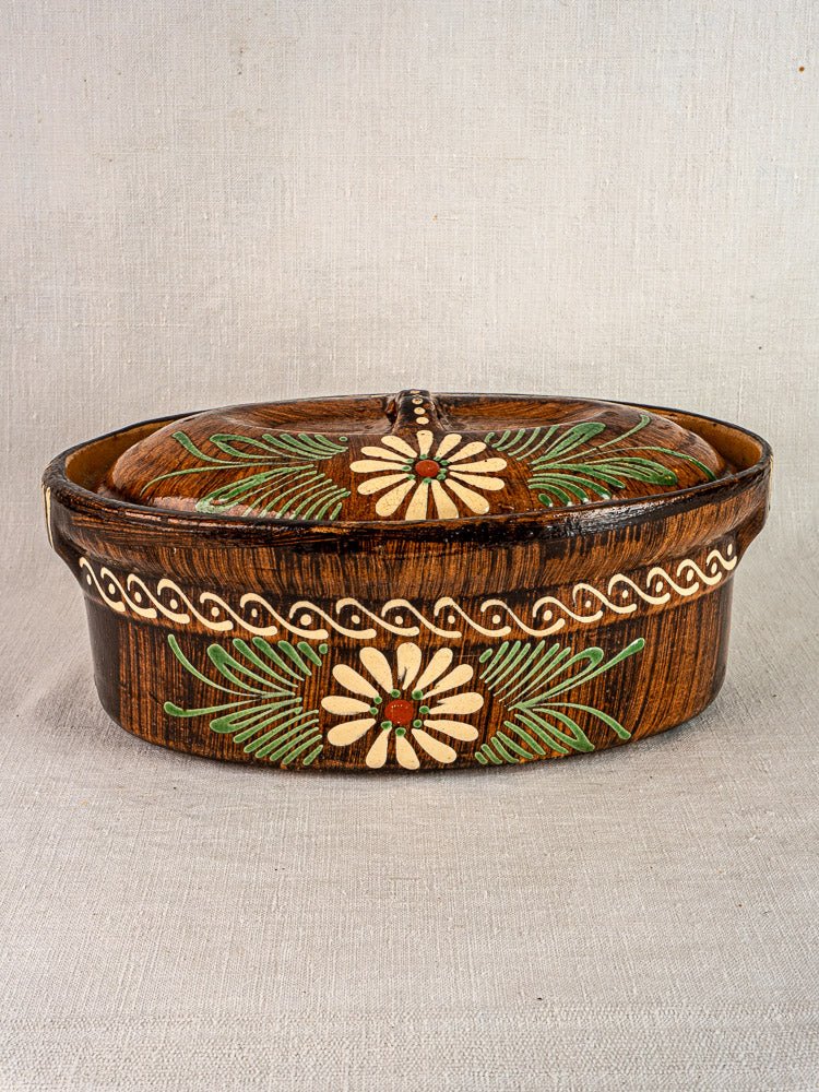 Antique French terracotta cookware set from Alsace with slip-decorated floral and green leaf motifs.