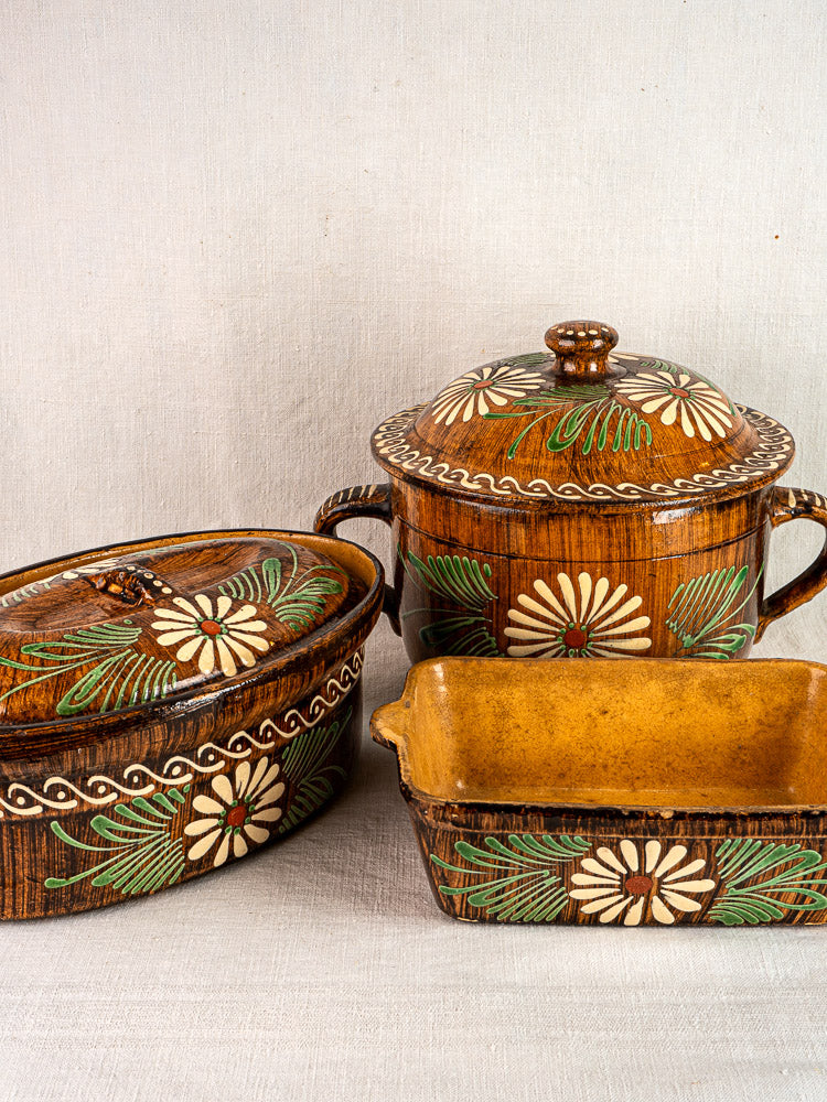 Set of three brown glazed Alsace terracotta baking dishes with white and green slip decoration.
