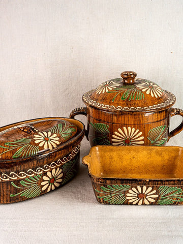 Set of three brown glazed Alsace terracotta baking dishes with white and green slip decoration.