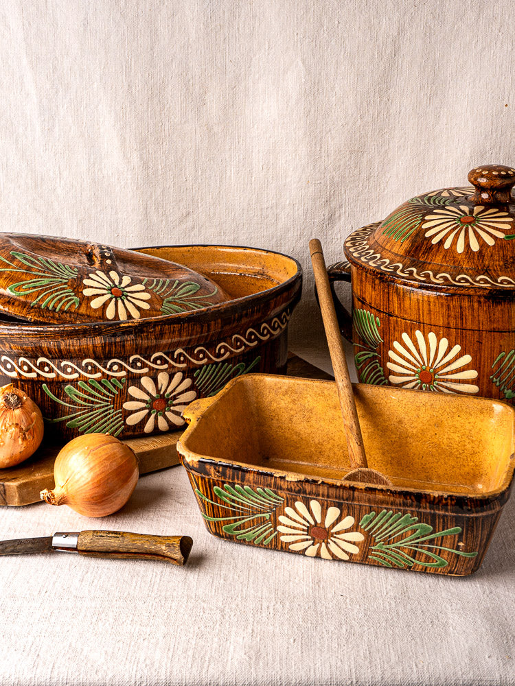 Set of three brown glazed Alsace terracotta baking dishes with white and green slip decoration.