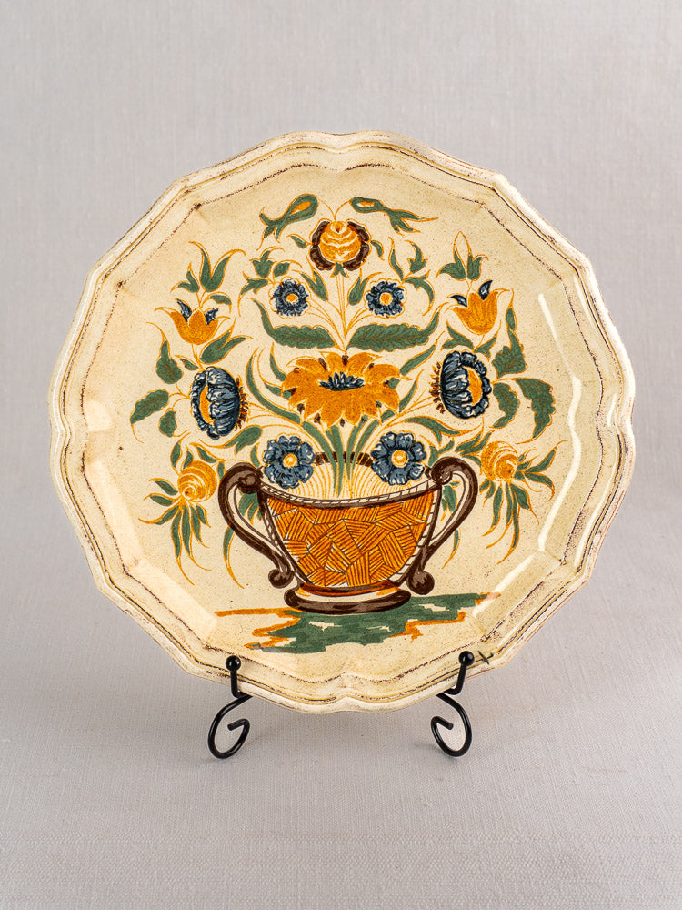 Vintage French Salins Clérissy faience plate with scalloped edges, hand-painted Moustiers floral basket, on metal stand.