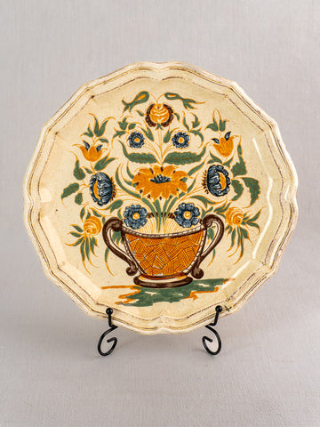 Vintage French Salins Clérissy faience plate with scalloped edges, hand-painted Moustiers floral basket, on metal stand.