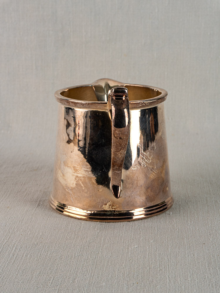 Antique English silver plate milk jug by Walker & Hall, circa 1900, with flared base and curved handle on light textured surface.
