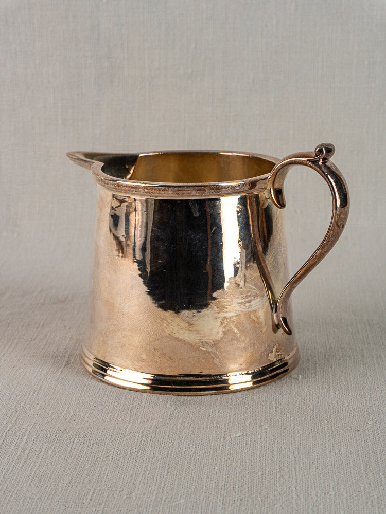 Antique English silver plate milk jug by Walker & Hall Sheffield, circa 1900, on neutral fabric with textured backdrop.