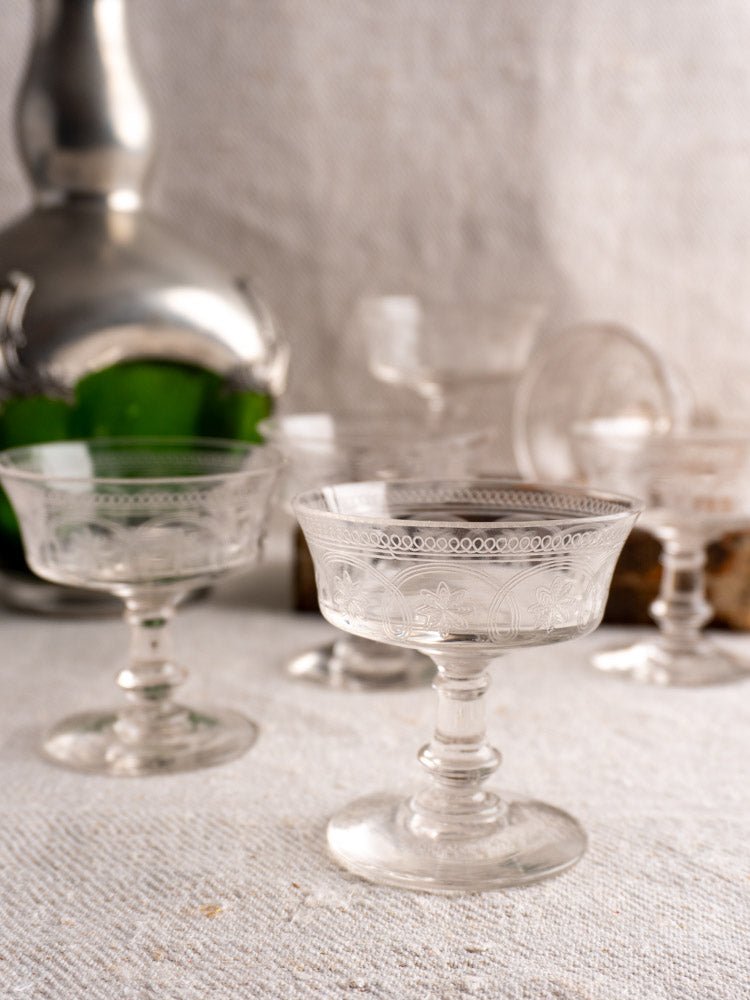 Set of six antique French uranium glass coupes c.1900 with delicate patterns on white cloth.
