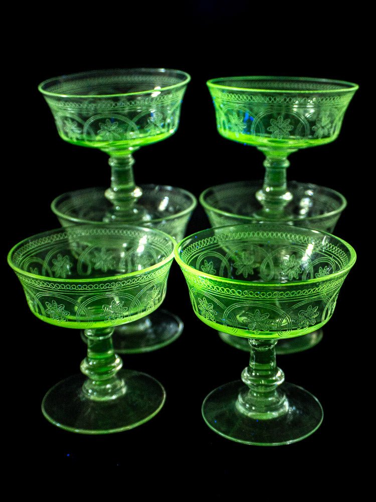 Set of six antique French uranium glass coupes, circa 1900, arranged against a black background.