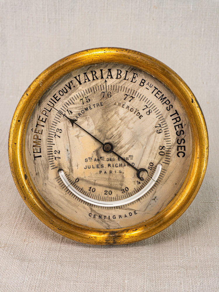 Antique French barometer by Jules Richard Paris with brass case, aged French dial, and ornate gold frame.