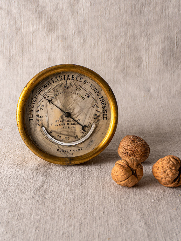 Antique French brass barometer by Jules Richard, gold rim, white face with French text, weather and centigrade display.