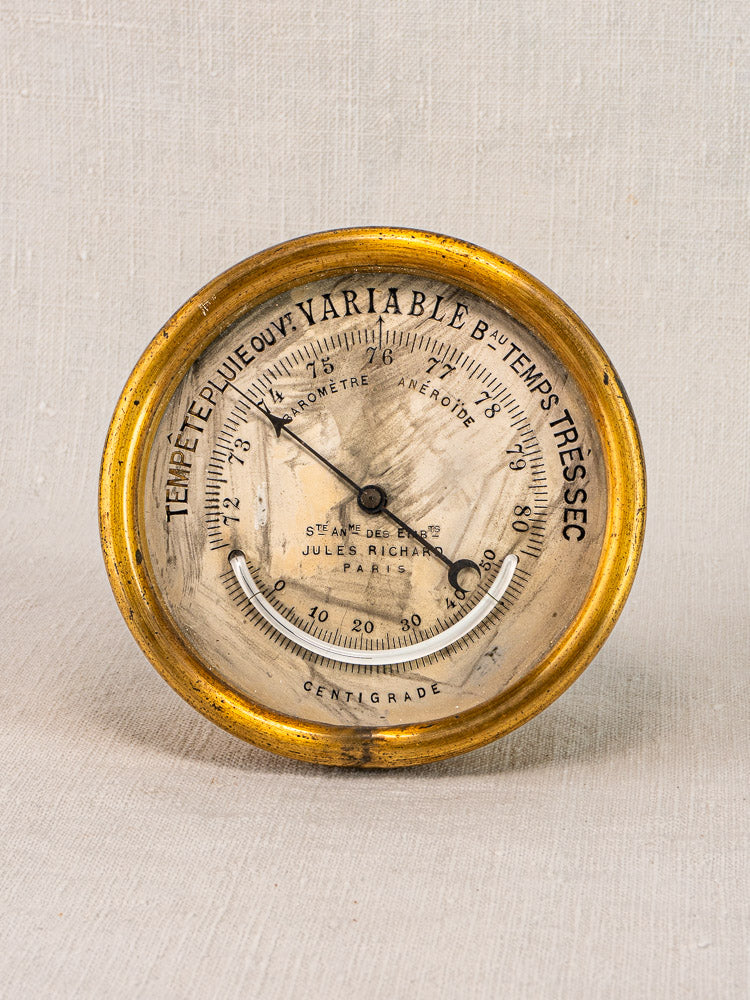 Antique French brass barometer by Jules Richard, gold rim, white face with French text, weather and centigrade display.