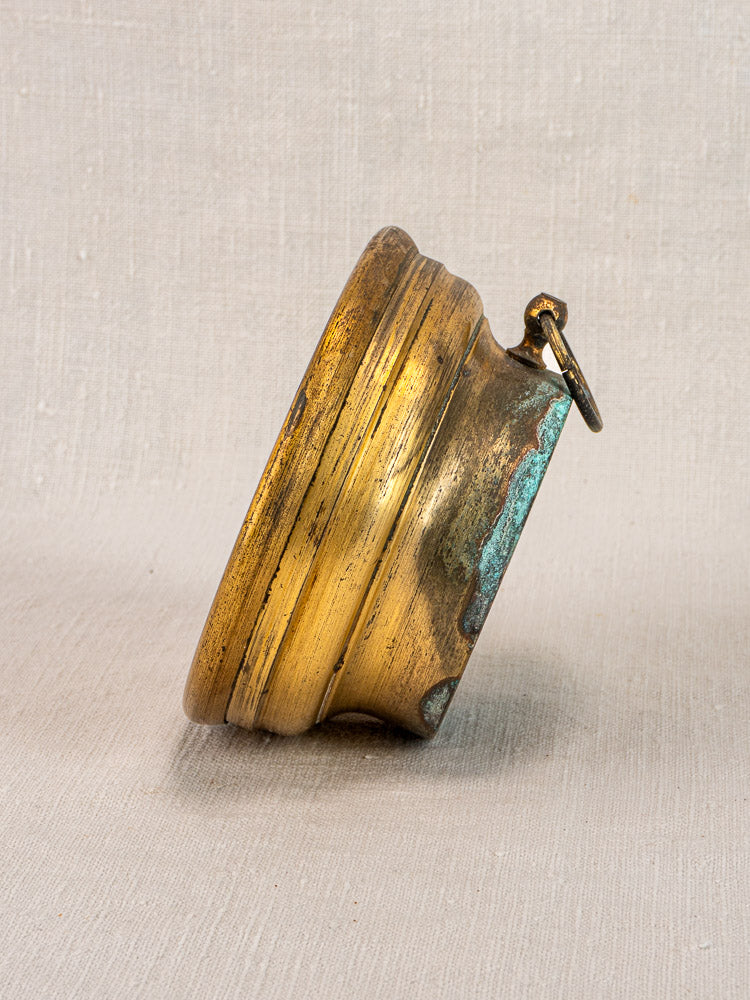 Antique French barometer by Jules Richard Paris with weathered brass case and green patina on light fabric background.