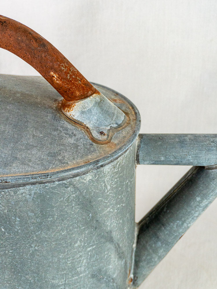 French antique zinc garden arrosoir, oval watering can with weathered finish and rusted handle.