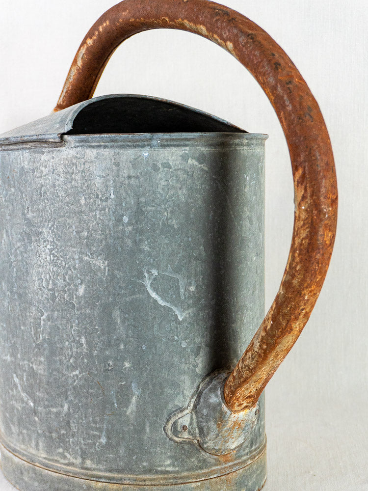 French zinc garden arrosoir antique oval watering can with large curved rusted handle.