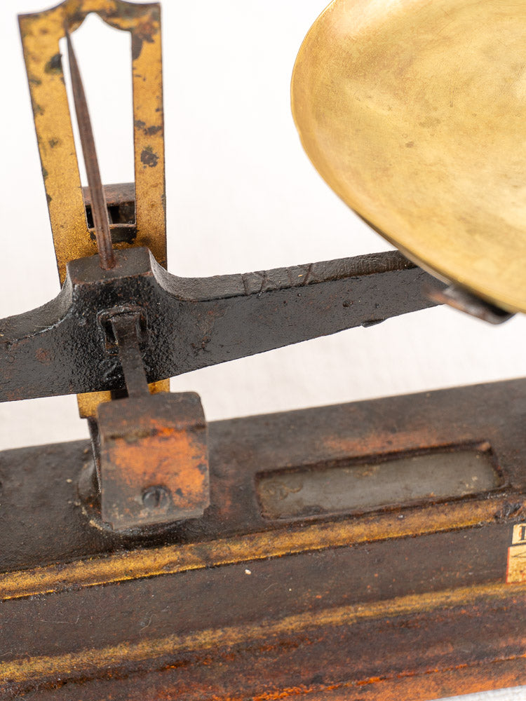 Antique French cast iron and brass Roberval Force 5 kg balance scale with corroded frame and brass weighing pan.