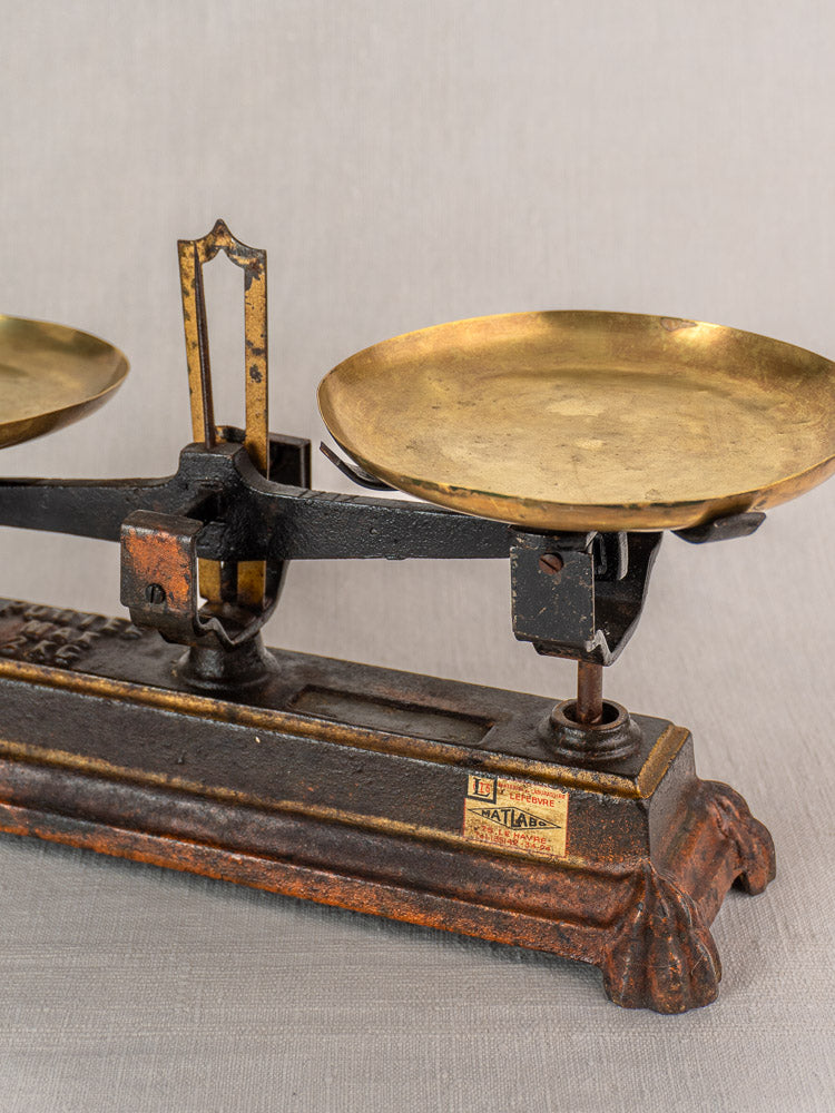 Antique French Roberval Force 5 Kg cast iron and brass balance scale with round pans on light gray surface.