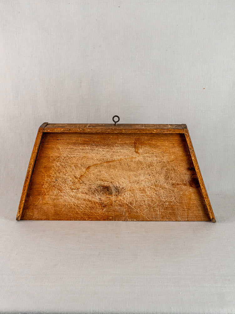 Antique French beech cutting board with knife marks, rectangular, against a neutral fabric backdrop.