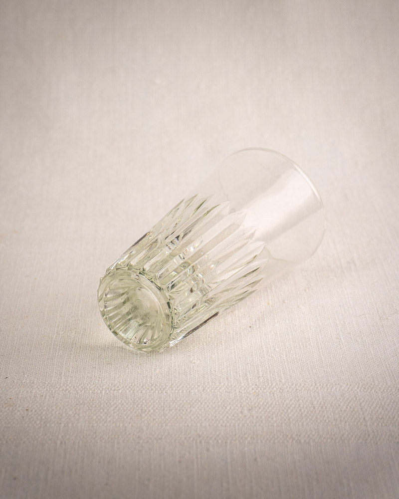 Vintage French bistro glass caddy with six fluted tumblers on textured fabric, classic café style with wrought iron accents.