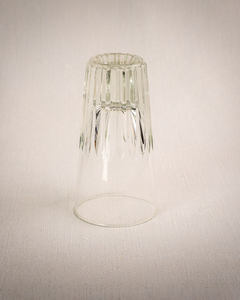 Vintage French bistro glass caddy with six fluted tumblers, wrought iron and rattan accents on light textured surface.