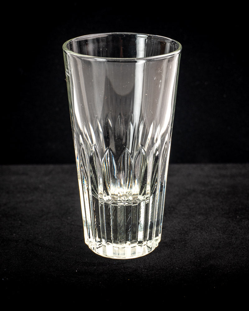 Vintage French bistro glass caddy with six fluted tumblers in wrought iron and rattan on black surface.