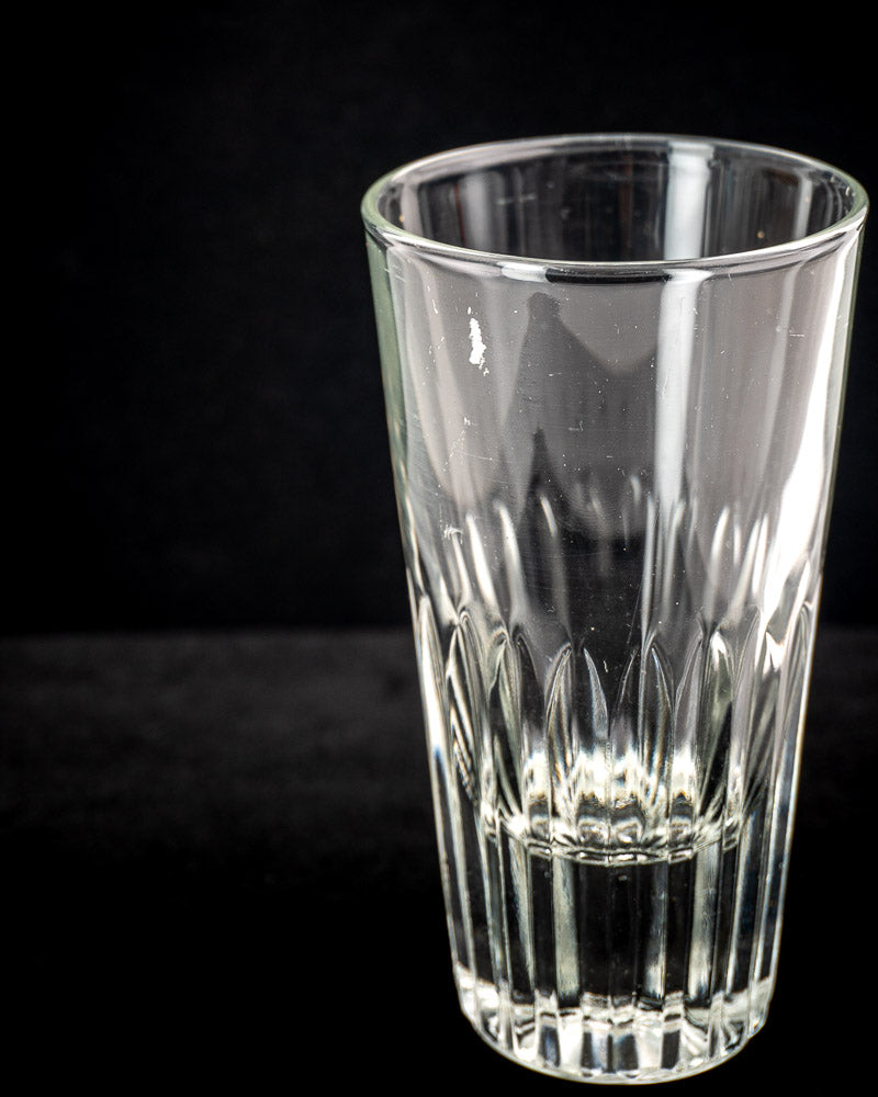 Vintage French bistro caddy in wrought iron and rattan with six fluted clear glass tumblers on a dark backdrop.