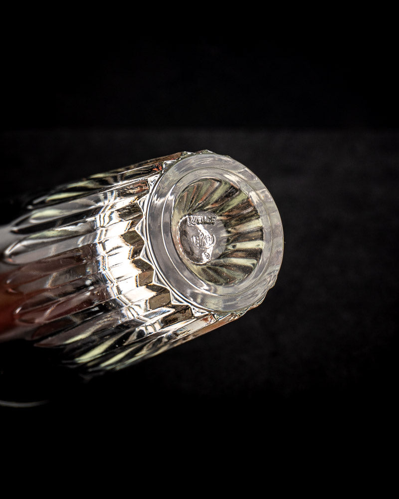 Vintage French bistro glass caddy with six faceted tumblers, fluted cuts, iron and rattan carrier, dark backdrop.