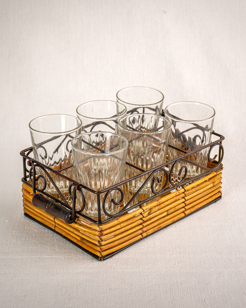 Set of six fluted tumblers in a vintage French bistro caddy with wrought iron and rattan accents.