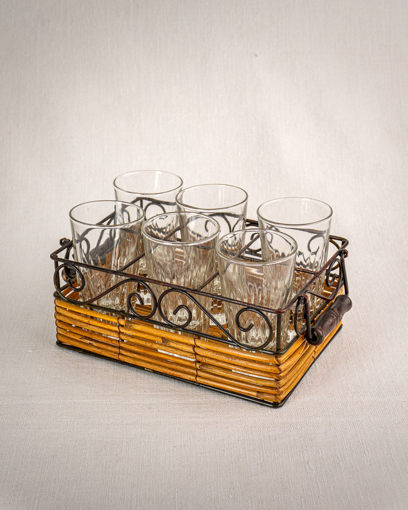 Set of six fluted French tumblers in a vintage bistro caddy with wrought iron and rattan handles.