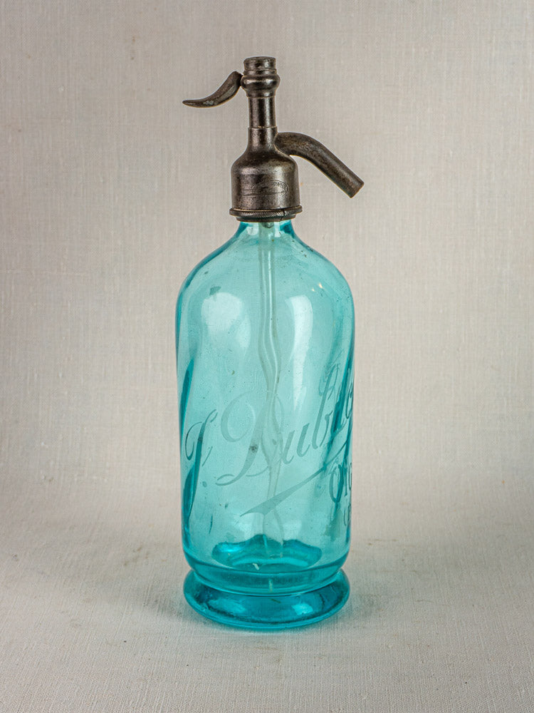 Antique French bistro seltzer bottle with vintage blue glass and metal siphon, etched script detailing.